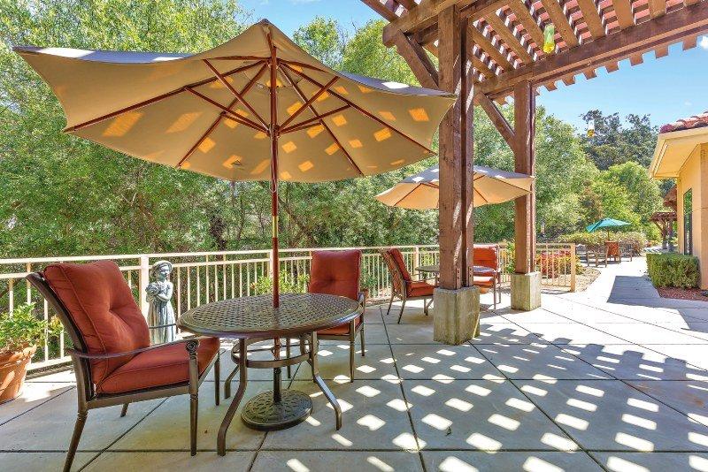 Saratoga Retirement Community outdoor patio with tables and umbrellas