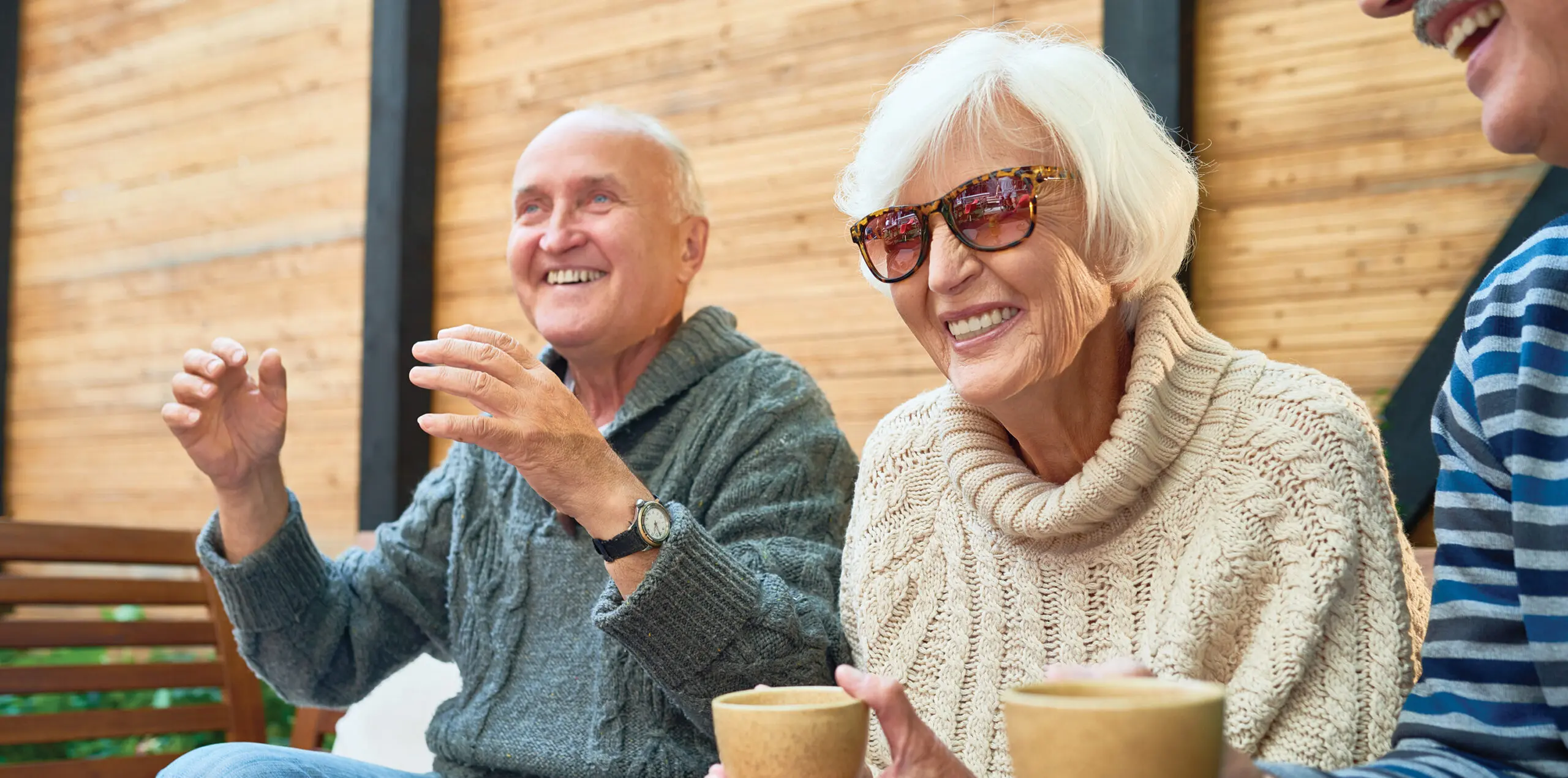Best friends smile and laugh outdoors with hot beverages