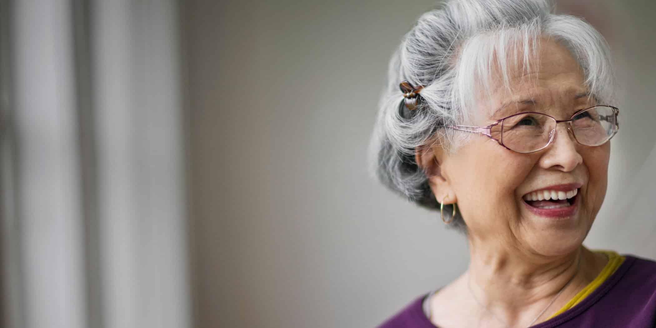 Senior woman smiles, looking away from the camera